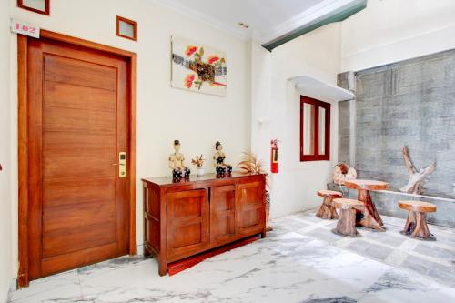 a room with a wooden door and a table at Collection O Jalan Malioboro Near Lempuyangan Station Formerly Hotel Vala in Yogyakarta