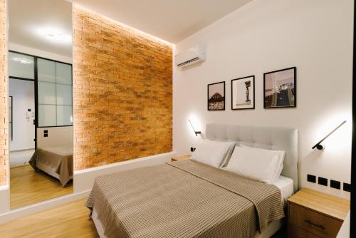 a bedroom with a bed and a brick wall at G Residence in Athens