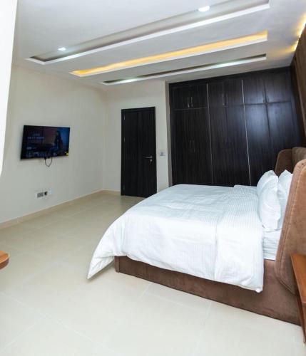 a bedroom with a large bed with a wooden headboard at Calini Apartment in Mobushipe
