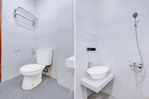 a white bathroom with a toilet and a sink at Collection O Jalan Malioboro Near Lempuyangan Station Formerly Hotel Vala in Yogyakarta