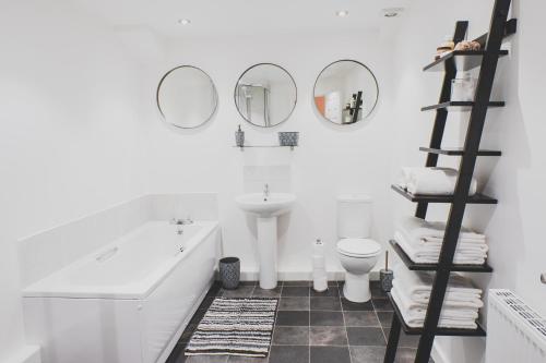 a bathroom with a sink and a toilet and mirrors at Discovery Suite – Simple2let Serviced Apartments in Halifax
