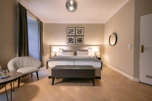 a bedroom with a bed and a table and chairs at Hotel Eisenhut in Rothenburg ob der Tauber