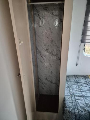 a bathroom with a glass shower in a room at Mobil-Home N 17 in Fourmies