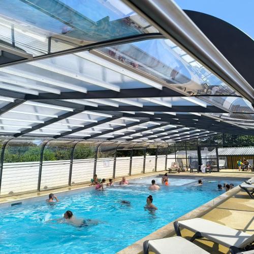 un groupe de personnes nageant dans une piscine dans l'établissement Camping A l'Abri de l'Océan, à Baye