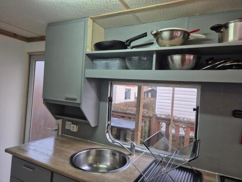 a kitchen with a sink and a window at Mobil-Home N 17 in Fourmies