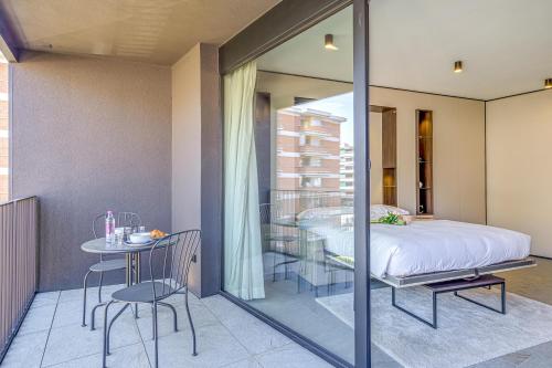 a bedroom with a bed and a table and chairs at ICON H Lugano - Luxury Suites & Apartments in Lugano