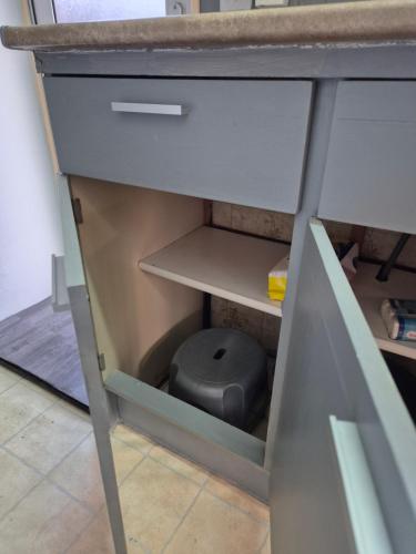 a drawer under a desk with a stool under it at Mobil-Home N 17 in Fourmies