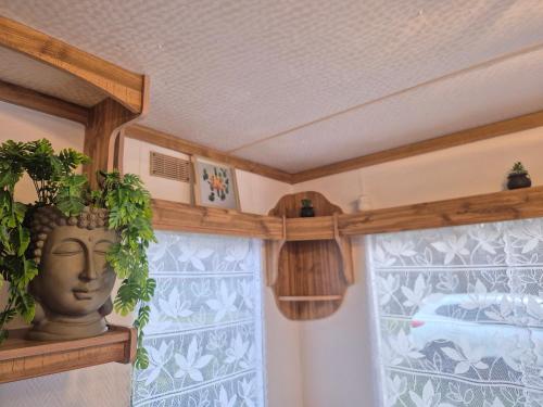 a room with a vase with a plant on a window at Mobil-Home N 17 in Fourmies