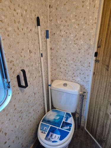 a bathroom with a toilet with the lid down at Mobil-Home N 17 in Fourmies