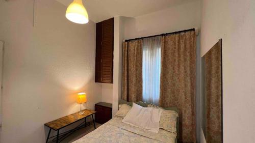 a bedroom with a bed and a window with a lamp at Petit appartement vintage in Dakar