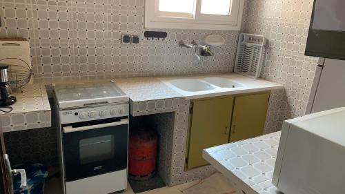 a small kitchen with a sink and a stove at Petit appartement vintage in Dakar