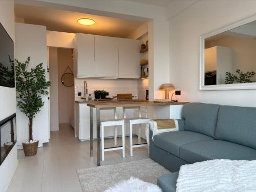 a living room with a couch and a kitchen at SEA VIEW Juweeltje in Knokke-Heist