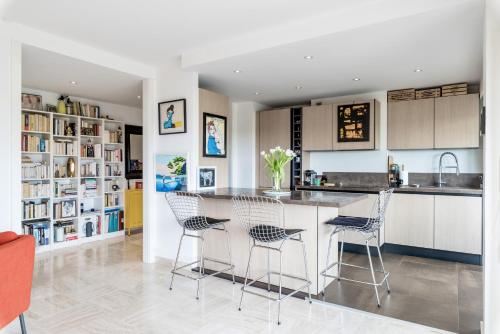 une cuisine avec un îlot doté de chaises et d'un comptoir dans l'établissement Solange By Terrys Homes, à Cannes