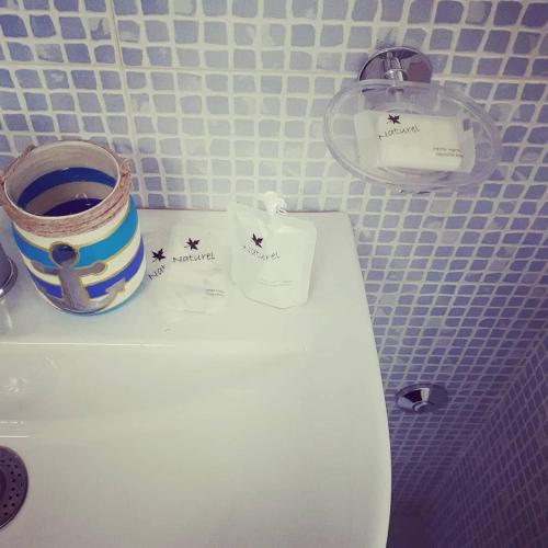 a toilet in a bathroom with a bucket on the tank at Sottovento Marzamemi Rooms&Relax in Marzamemi