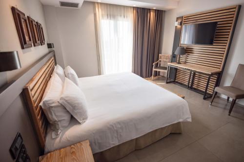 Ένα ή περισσότερα κρεβάτια σε δωμάτιο στο Movenpick Resort Agios Nikolaos Sivota