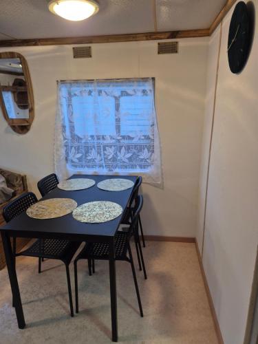 a table and chairs in a small room with a window at Mobil-Home N 17 in Fourmies