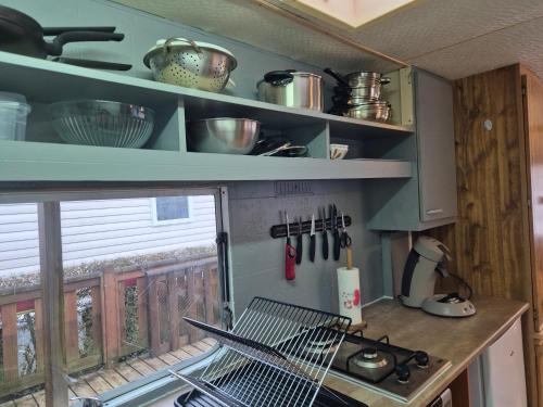 a kitchen with a stove and a window at Mobil-Home N 17 in Fourmies