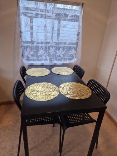 a black table with four plates on top of it at Mobil-Home N 17 in Fourmies