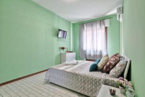 a bedroom with a bed in a room with green walls at Venice Miramare Residence 1 in Zelo