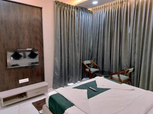a bedroom with a bed and a large window at Hotel Laxmi Elite Karad in Karad