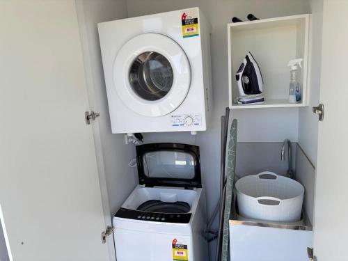 a washer and dryer in a tiny house at 2BR-2BR-2Cars -CBD-Pool-sleeps 6 in Canberra