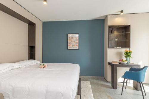 a bedroom with a white bed and a blue wall at ICON H Lugano - Luxury Suites & Apartments in Lugano