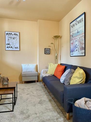a living room with a blue couch and a chair at Urlaub in der Eifel direkt am Rursee - Seeblick in Simmerath