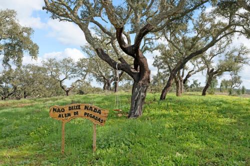 a sign in a field with a tree at Herdade Vale de Gaios in Odemira