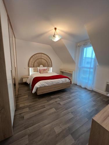 une chambre avec un grand lit avec une couverture rouge dans l'établissement Garogwen by Madame est Servie, à Pleumeur-Bodou