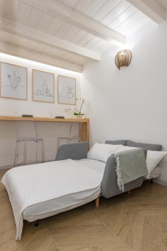 two beds in a room with white walls and wooden floors at Loft La Torre in Cagliari