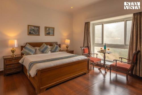 a bedroom with a large bed and a window at StayVista at Pineview @ Albert Estate in Mussoorie