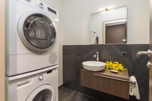 a bathroom with a washing machine and a sink at ICON H Lugano - Luxury Suites & Apartments in Lugano