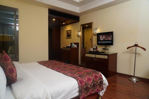 a hotel room with a bed and a television at Fortune Select JP Cosmos, Bengaluru - Member ITC Hotels' Group in Bengaluru