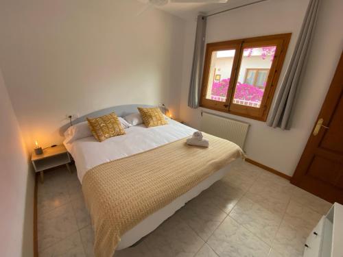 a bedroom with a large bed with a window at El Penell Apartament Ponent in Vilamaniscle