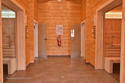 a hallway of a wooden building with a fire hydrant on the wall at Feriendorf Blauvogel Blauvogel 001 in Hasselfelde