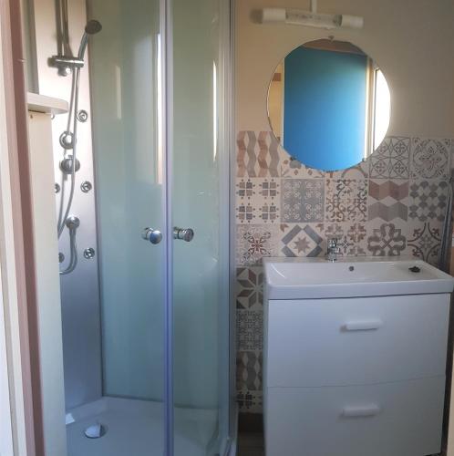 une salle de bain avec une douche, un lavabo et un miroir dans l'établissement Camping A l'Abri de l'Océan, à Baye