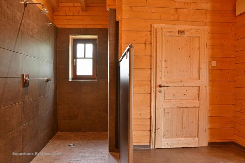 a bathroom with a door and a window at Feriendorf Blauvogel Blauvogel 031 in Hasselfelde