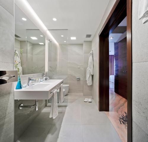 a bathroom with a sink and a toilet and a mirror at Hotel Murcia Rincón de Pepe Affiliated by Meliá in Murcia