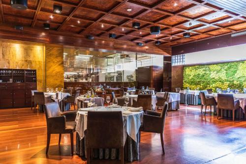a restaurant with tables and chairs and a large window at Hotel Murcia Rincón de Pepe Affiliated by Meliá in Murcia
