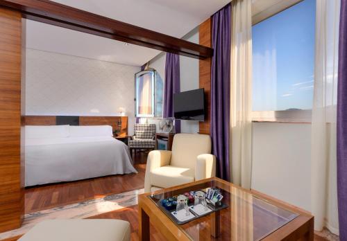 a hotel room with a bed and a desk at Hotel Murcia Rincón de Pepe Affiliated by Meliá in Murcia