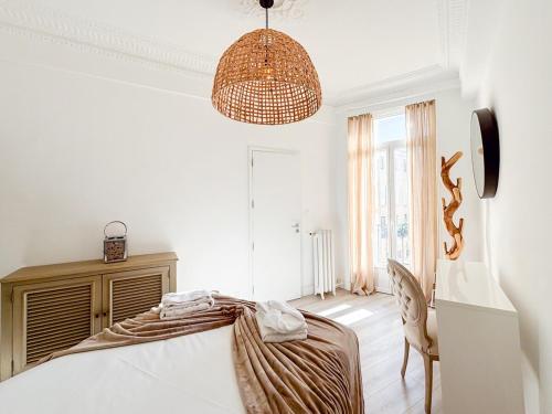 une chambre avec un lit et un lustre dans l'établissement #12 1BDR Joffre, Central 5min from Old Town AC & WIFI, à Nice