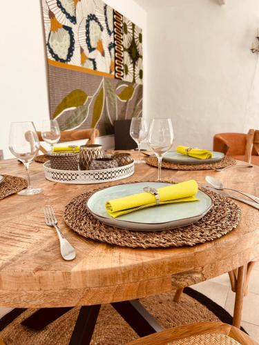 a wooden table with a yellow napkin on top of it at "ENTRE LA VIGNE et L'OLIVIER" in Taulignan
