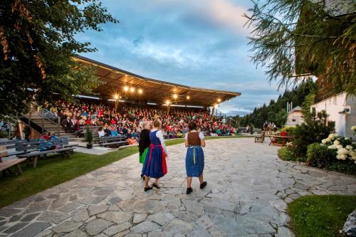 two women walking in front of a crowd of people at Landhaus GRETE in Stubenberg
