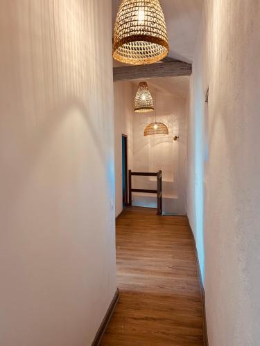 a hallway with white walls and a ceiling with a chandelier at "ENTRE LA VIGNE et L'OLIVIER" in Taulignan