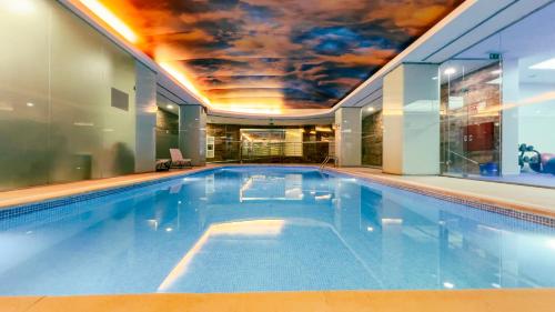 an indoor swimming pool with a ceiling covered in a mural at VIP Executive Entrecampos Hotel & Conference in Lisbon