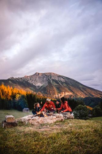 a group of people sitting around a fire in front of a mountain at Nestelberg 17 in Lackenhof