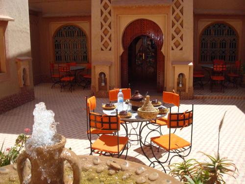 a patio with a table and chairs in a building at Kasbah Ait Kassi in Boumalne