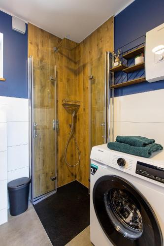 a washing machine in a bathroom with a shower at Forrest Houses Bartosze in Bartosze