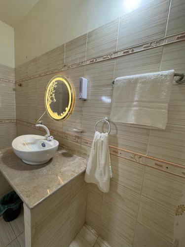une salle de bain avec un lavabo et un miroir dans l'établissement Rosewood Cottage, à Karachi