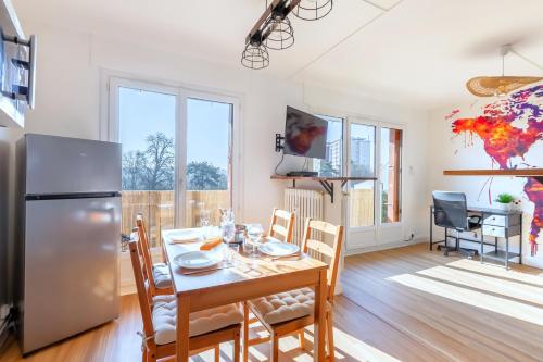 une cuisine et une salle à manger avec une table et un réfrigérateur dans l'établissement Le Chalet - GARE 3 min - PARIS 20 min - DISNEY 25 min - Lumineux & Chaleureux - Free WIFI, à Thorigny-sur-Marne